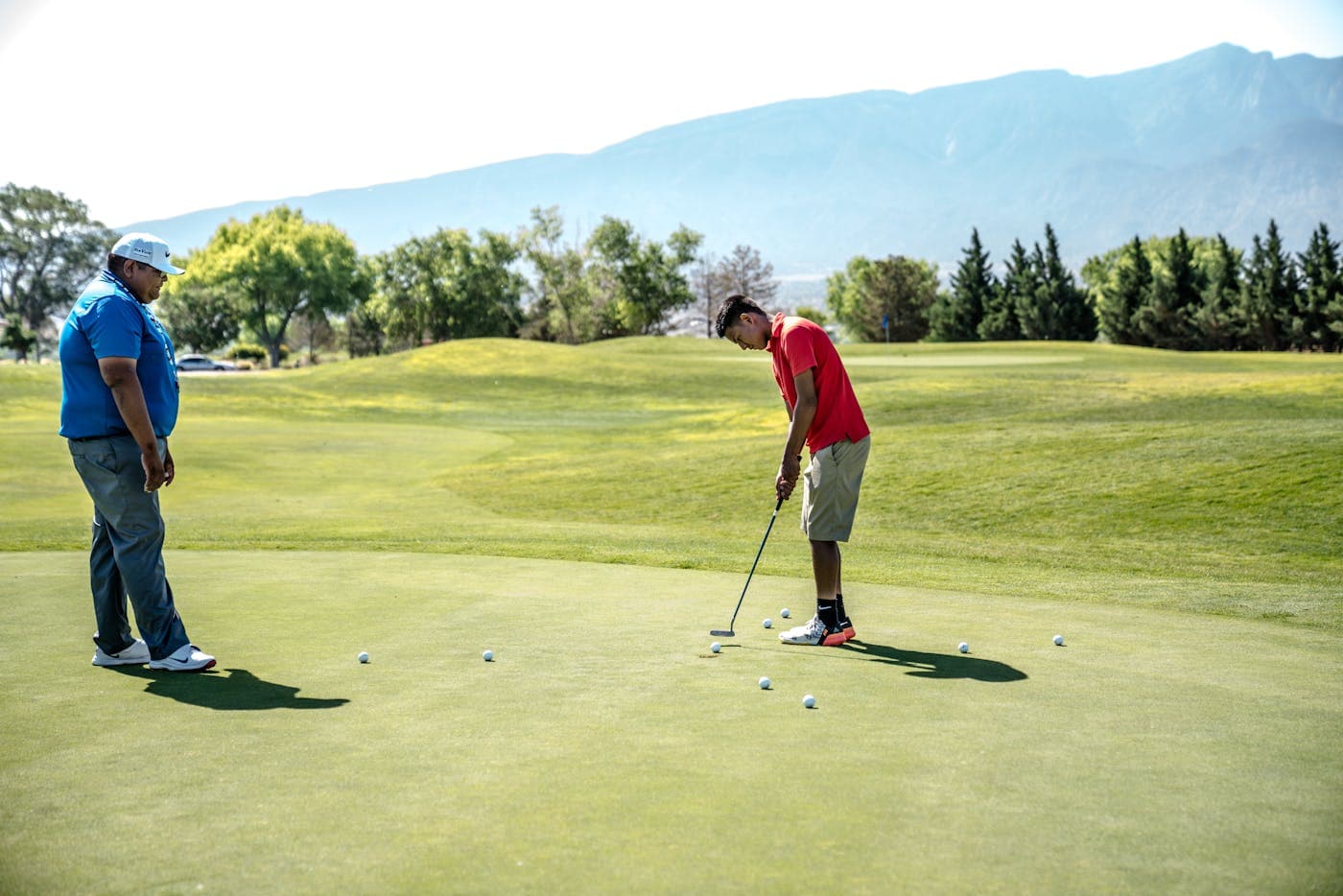Golf instructor with student on the green